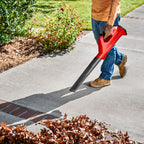 12V Cordless Blower blowing leafs on a walkway from a front view