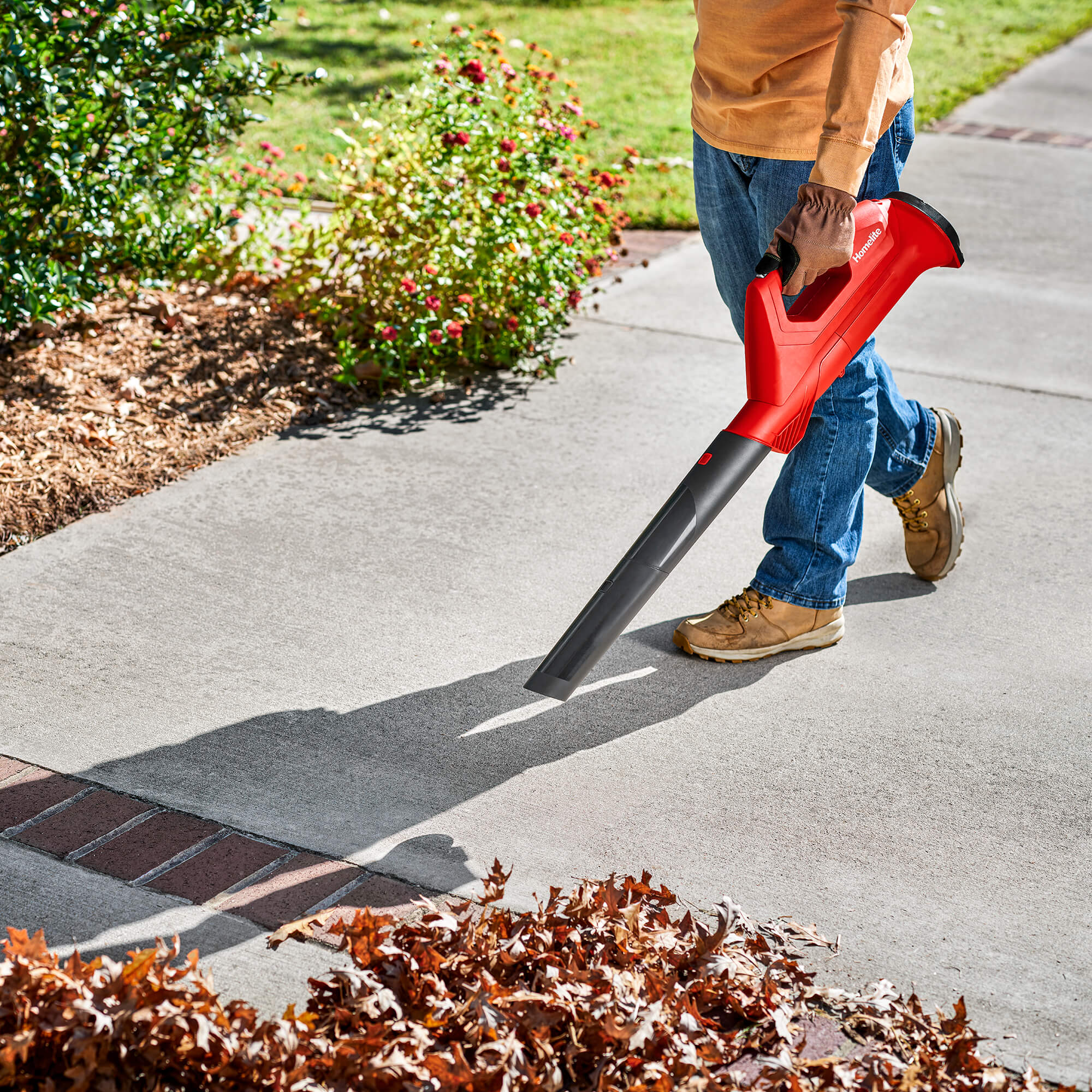 12V Cordless Blower blowing leafs on a walkway from a front view