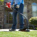 26cc 2-Cycle Curved Shaft Trimmer weed wacking in front yard