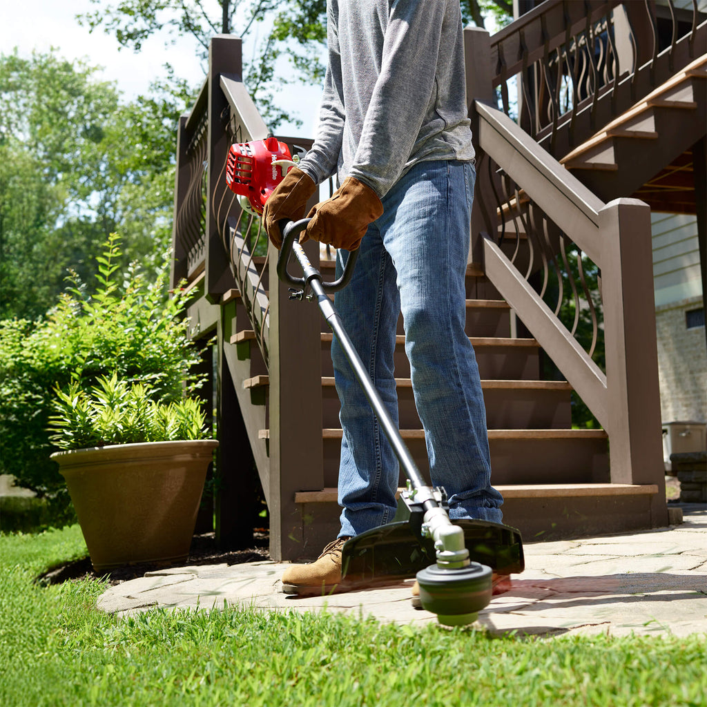 26cc 2-Cycle Straight Shaft Trimmer trimming grass around walkway